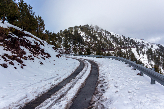View of a winding road cutting through a snow laden landscape with evergreens dotting the hillsides under a moody sky Pir Chanasi Azad Kashmir Pakistan. View of a winding road cutting through a snow laden landscape with evergreens dotting the hillsides under a moody sky Pir Chanasi Azad Kashmir Pakistan.