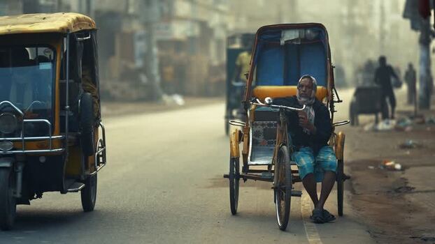 View of a rickshaw puller on a street in Bogura Bangladesh. View of a rickshaw puller on a street in Bogura Bangladesh.