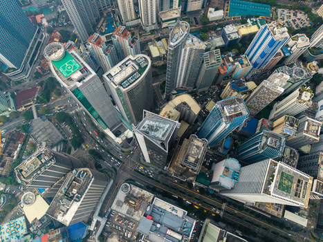 Aerial view of modern skyscrapers with helipads and busy city streets in the central business district of Makati City Metro Manila Philippines.