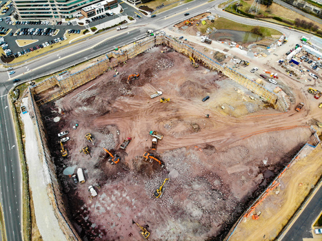 Reston Virginia United States 12 March 2019 Aerial view of a large construction site with excavators and earthmoving equipment working on the dirt foundation. Reston Virginia United States 12 March 2019 Aerial view of a large construction site with excavators and earthmoving equipment working on the dirt foundation.