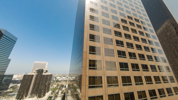 Aerial view of the skyscrapers in Downtown Los Angeles with glass facades reflecting the bright blue sky in Los Angeles California United States.