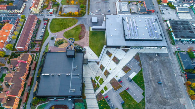 Aerial view of a modern sports and swimming facility with a water slide parking areas and surrounding residential buildings in Sweden. Aerial view of a modern sports and swimming facility with a water slide parking areas and surrounding residential buildings in Sweden.