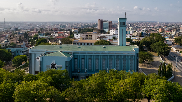 Aerial view of Holy Spirit Cathedral with its blue facade and tall bell tower surrounded by trees and the urban landscape of Accra Greater Accra Region Ghana. Aerial view of Holy Spirit Cathedral with its blue facade and tall bell tower surrounded by trees and the urban landscape of Accra Greater Accra Region Ghana.