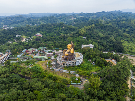 Aerial view of the golden Maitreya Buddha statue at Fo Guang Shan Buddha Museum surrounded by lush green hills and temple architecture in Dashu District Kaohsiung Taiwan. Aerial view of the golden Maitreya Buddha statue at Fo Guang Shan Buddha Museum surrounded by lush green hills and temple architecture in Dashu District Kaohsiung Taiwan.