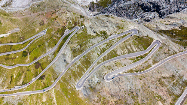 Aerial view of the famous Stelvio Pass Serpentines featuring dramatic hairpin turns winding through the rugged alpine landscape of Stilfs Trentino Alto Adige Italy.