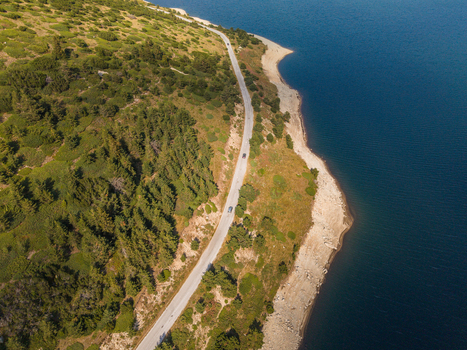 Aerial view of Belmeken reservoir with a winding road along the shoreline surrounded by dense pine forests and rugged terrain Pazardzhik Bulgaria. Aerial view of Belmeken reservoir with a winding road along the shoreline surrounded by dense pine forests and rugged terrain Pazardzhik Bulgaria.