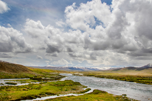 View of Deosai National Park with a winding river flowing through green plains under a dramatic cloudy sky Skardu Gilgit Pakistan. View of Deosai National Park with a winding river flowing through green plains under a dramatic cloudy sky Skardu Gilgit Pakistan.