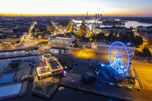 Aerial view of Uspenski Cathedral and the illuminated SkyWheel Helsinki at the harbor during twilight in Helsinki Uusimaa Finland.