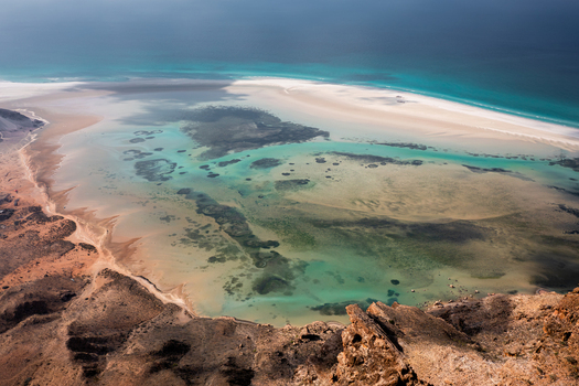 Aerial view of the turquoise waters and white sandbanks of Detwah Lagoon surrounded by rugged cliffs and the Arabian Sea in Qalansiyah wa Abd Al Kuri Socotra Yemen. Aerial view of the turquoise waters and white sandbanks of Detwah Lagoon surrounded by rugged cliffs and the Arabian Sea in Qalansiyah wa Abd Al Kuri Socotra Yemen.