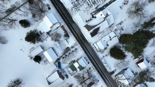 Aerial view of Sporting Hill covered in fresh snow featuring residential houses with snow covered rooftops bare trees and a clear asphalt road in Hampden Township Pennsylvania United States. Aerial view of Sporting Hill covered in fresh snow featuring residential houses with snow covered rooftops bare trees and a clear asphalt road in Hampden Township Pennsylvania United States.