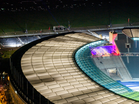 Berlin Germany 26 September 2026 Aerial view of Olympiastadion Berlin at night highlighting the illuminated stadium roof and seating areas under bright floodlights.