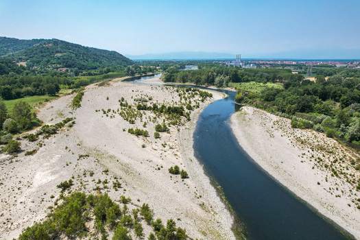 Aerial view of the Po River showing severe drought conditions with exposed riverbed and low water levels near Chivasso Piedmont Italy.