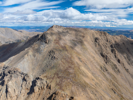 Aerial view of Mount Harvard with its rugged rocky peak and steep slopes under a bright blue sky with scattered clouds in Buena Vista Colorado United States. Aerial view of Mount Harvard with its rugged rocky peak and steep slopes under a bright blue sky with scattered clouds in Buena Vista Colorado United States.