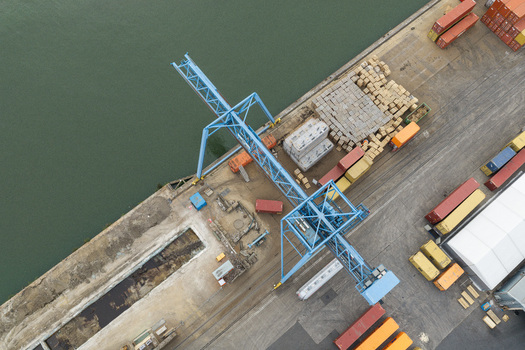 Aerial view of Haven Genk container terminal with a large blue port crane shipping containers and industrial infrastructure along the waterfront in Genk Vlaanderen Belgium.