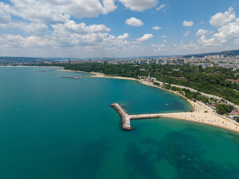 Aerial view of the Alley First promenade along the coastline in Varna featuring sandy beaches breakwaters and the city skyline under a blue sky in Varna Varna Bulgaria. Aerial view of the Alley First promenade along the coastline in Varna featuring sandy beaches breakwaters and the city skyline under a blue sky in Varna Varna Bulgaria.