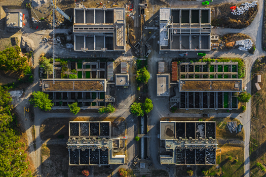 Aerial view of water treatment plant with industrial basins filtration tanks and surrounding green vegetation in Rome Lazio Italy.