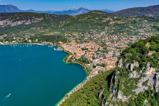 Aerial view of the town of Garda on the shores of Lake Garda with colorful buildings lush green hills and turquoise waters under a clear blue sky Garda Veneto Italy. Aerial view of the town of Garda on the shores of Lake Garda with colorful buildings lush green hills and turquoise waters under a clear blue sky Garda Veneto Italy.