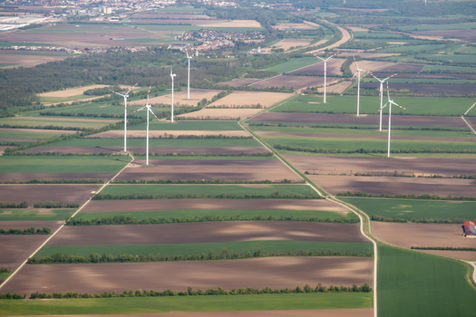 Aerial view of wind turbines standing in a patchwork of agricultural fields under a clear sky Lower Austria Austria. Aerial view of wind turbines standing in a patchwork of agricultural fields under a clear sky Lower Austria Austria.