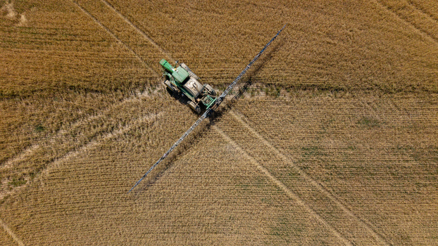 Aerial view of a tractor spraying a large agricultural field in Philadelphia Western Cape South Africa. Aerial view of a tractor spraying a large agricultural field in Philadelphia Western Cape South Africa.