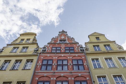 View of historic colorful tenement houses with ornate gables and detailed facades under a blue sky in Gdansk Pomeranian Voivodeship Poland. View of historic colorful tenement houses with ornate gables and detailed facades under a blue sky in Gdansk Pomeranian Voivodeship Poland.