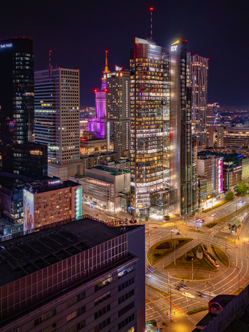 Aerial view of the illuminated Warsaw skyline at night featuring modern skyscrapers and the Palace of Culture and Science overlooking a busy city roundabout in Warsaw Poland. Aerial view of the illuminated Warsaw skyline at night featuring modern skyscrapers and the Palace of Culture and Science overlooking a busy city roundabout in Warsaw Poland.