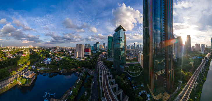 South Jakarta Indonesia 10 January 2026 Aerial view of the modern skyline featuring skyscrapers an elevated railway track and lush urban greenery under a bright cloudy sky. South Jakarta Indonesia 10 January 2026 Aerial view of the modern skyline featuring skyscrapers an elevated railway track and lush urban greenery under a bright cloudy sky.