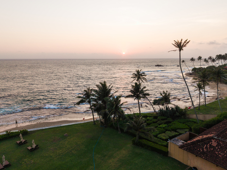 Aerial view of a tropical coastline with palm trees sandy beach and ocean waves during sunset in Galle Southern Province Sri Lanka. Aerial view of a tropical coastline with palm trees sandy beach and ocean waves during sunset in Galle Southern Province Sri Lanka.