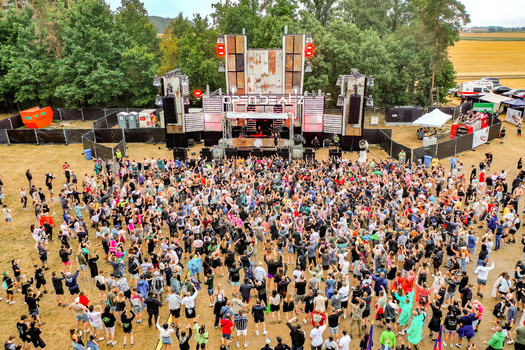 Herzogenaurach Germany 22 July 2022 Aerial view of the Open Beatz Festival main stage with a large crowd of people dancing surrounded by lush trees and rural fields. Herzogenaurach Germany 22 July 2022 Aerial view of the Open Beatz Festival main stage with a large crowd of people dancing surrounded by lush trees and rural fields.