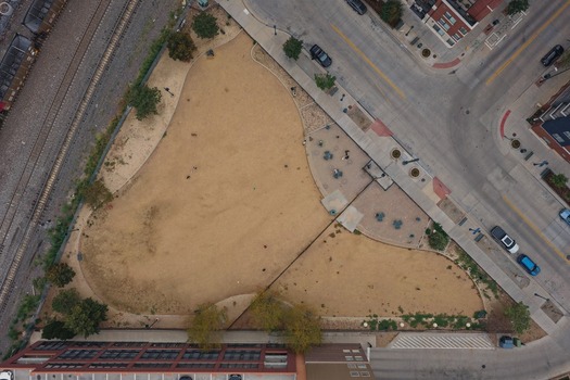 Aerial view of an urban park with dry grass and walking paths situated next to railroad tracks and city streets in Denver Colorado United States. Aerial view of an urban park with dry grass and walking paths situated next to railroad tracks and city streets in Denver Colorado United States.