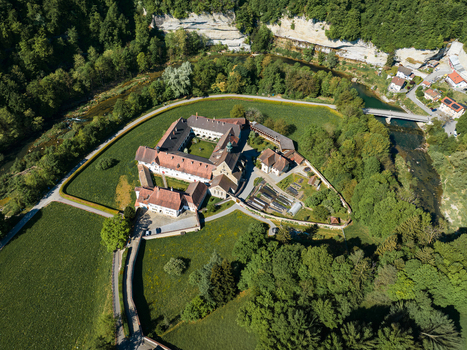Aerial view of La Maigrauge abbey complex with its red tiled roofs and central courtyard surrounded by lush green fields and the Sarine river Fribourg Fribourg Switzerland. Aerial view of La Maigrauge abbey complex with its red tiled roofs and central courtyard surrounded by lush green fields and the Sarine river Fribourg Fribourg Switzerland.