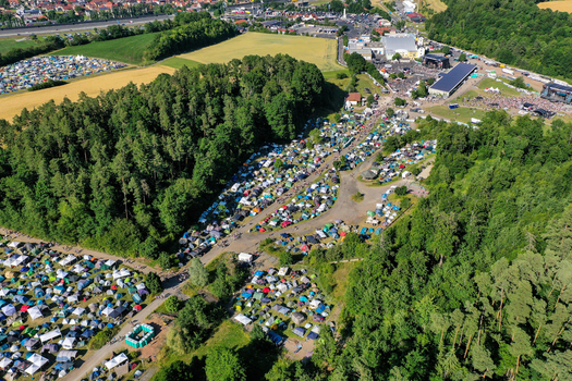 Aerial view of the Eventzentrum Strohofer Geiselwind musichall featuring a large campsite and festival stages surrounded by lush green forests in Geiselwind Bayern Germany. Aerial view of the Eventzentrum Strohofer Geiselwind musichall featuring a large campsite and festival stages surrounded by lush green forests in Geiselwind Bayern Germany.