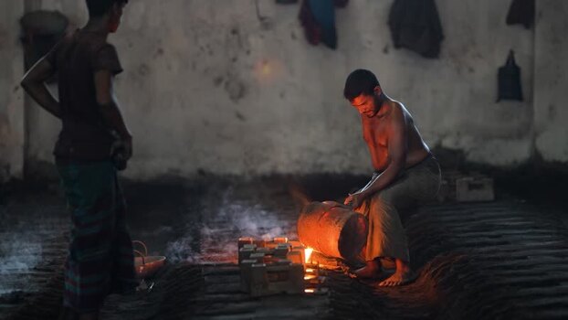 View of a worker pouring molten metal in a foundry Bangladesh.