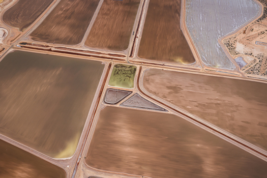 Aerial view of salt evaporation ponds with varying shades of brown tan and green water separated by earthen embankments in Kalbarri Western Australia Australia. Aerial view of salt evaporation ponds with varying shades of brown tan and green water separated by earthen embankments in Kalbarri Western Australia Australia.