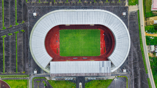 Aerial view of Godswill Akpabio Stadium with its distinctive oval shape green pitch red running track and surrounding parking lots in Uyo Akwa Ibom Nigeria. Aerial view of Godswill Akpabio Stadium with its distinctive oval shape green pitch red running track and surrounding parking lots in Uyo Akwa Ibom Nigeria.