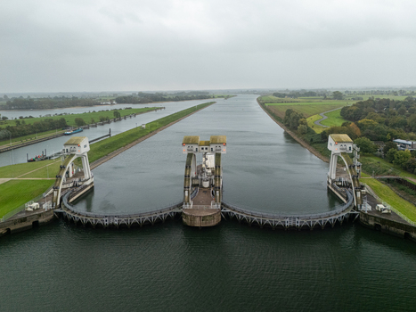 Aerial view of Sluis en stuwcomplex Hagestein a weir and lock complex on the Lek River with concrete structures steel gates and green fields in Hagestein Utrecht Netherlands.