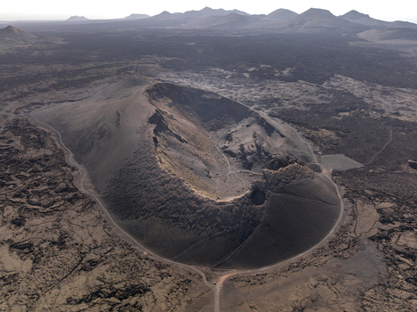 Aerial view of the volcanic crater in the arid landscape of Timanfaya National Park in Lanzarote Canarias Spain. Aerial view of the volcanic crater in the arid landscape of Timanfaya National Park in Lanzarote Canarias Spain.