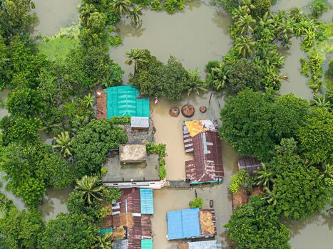 Banshkhali Upazila Bangladesh 10 July 2026 Aerial view of flooded rural houses submerged in murky water surrounded by lush green trees and vegetation after heavy monsoon rains. Banshkhali Upazila Bangladesh 10 July 2026 Aerial view of flooded rural houses submerged in murky water surrounded by lush green trees and vegetation after heavy monsoon rains.