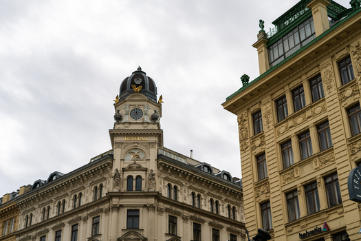 View of the historic Generali building featuring an ornate clock tower and dome under an overcast sky in Vienna Vienna Austria. View of the historic Generali building featuring an ornate clock tower and dome under an overcast sky in Vienna Vienna Austria.