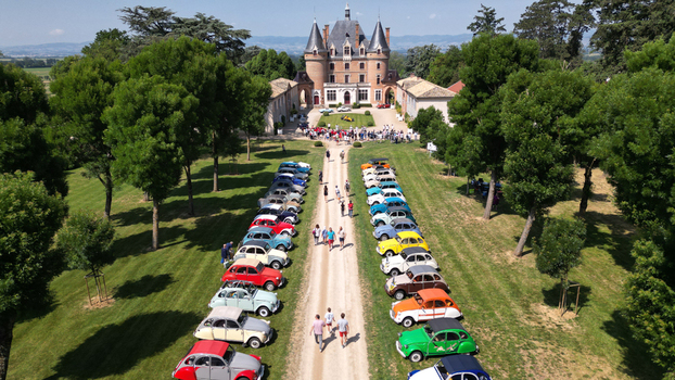 Francheleins France 04 June 2023 Aerial view of Chateau de Vataneins with vintage cars parked along the driveway and people walking on the lawn under a clear sky. Francheleins France 04 June 2023 Aerial view of Chateau de Vataneins with vintage cars parked along the driveway and people walking on the lawn under a clear sky.
