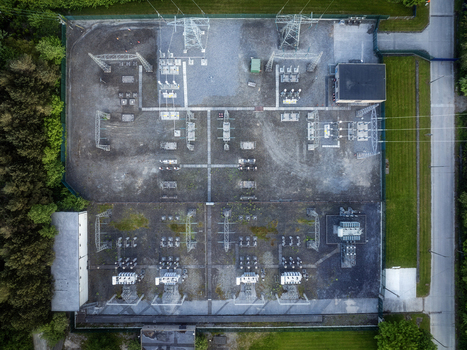 Aerial view of an electrical substation with transformers and power lines surrounded by lush green trees in Drogheda County Louth Ireland. Aerial view of an electrical substation with transformers and power lines surrounded by lush green trees in Drogheda County Louth Ireland.