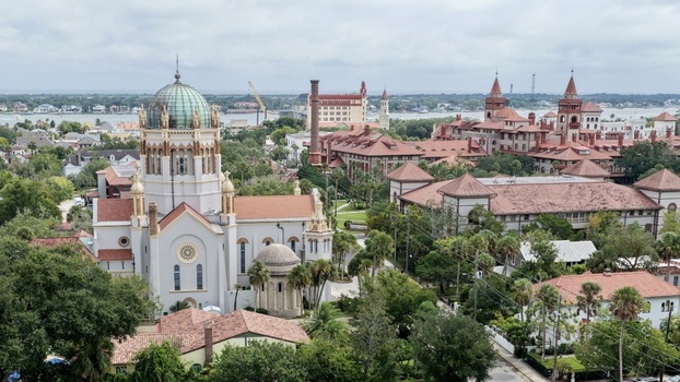 Aerial view of Memorial Presbyterian Church with its iconic dome surrounded by historic buildings with red tile roofs and lush greenery in St. Augustine Florida United States.