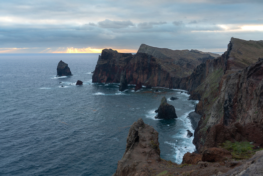 Aerial view of rugged volcanic cliffs and rocky sea stacks along the coastline of Madeira. Aerial view of rugged volcanic cliffs and rocky sea stacks along the coastline of Madeira.