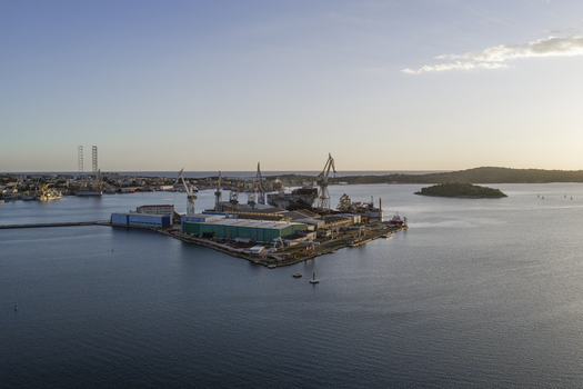 Aerial view of Pola Port shipyard with industrial cranes large warehouses and calm waters in Pula Istarska zupanija Croatia. Aerial view of Pola Port shipyard with industrial cranes large warehouses and calm waters in Pula Istarska zupanija Croatia.