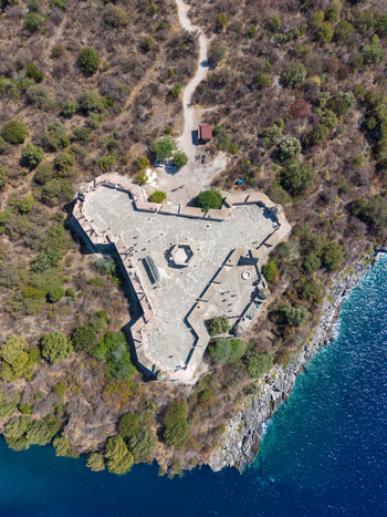 Aerial view of the triangular Castle of Porto Palermo surrounded by rugged coastal vegetation and the deep blue Ionian Sea in Porto Palermo Qarku i Vlores Albania.