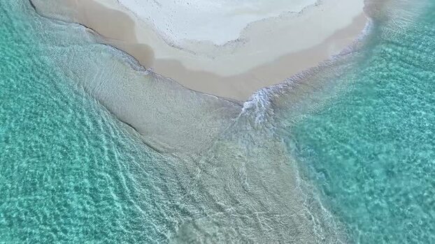 Aerial view of turquoise ocean waves washing over a white sandbar Maldives. Aerial view of turquoise ocean waves washing over a white sandbar Maldives.