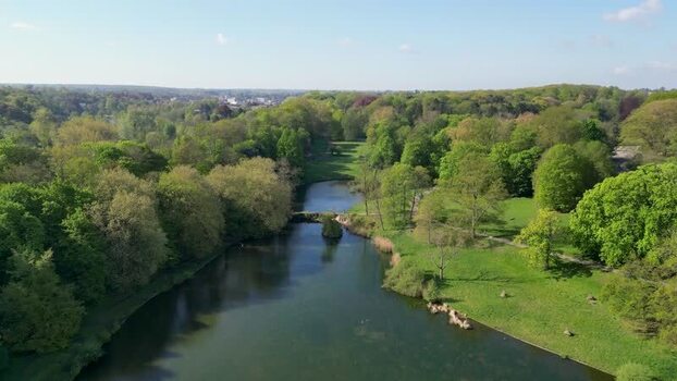 Aerial view of a lush green park and a calm lake in Belgium. Aerial view of a lush green park and a calm lake in Belgium.