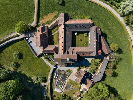 Aerial view of La Maigrauge Abbey featuring its historic red tiled roofs central courtyard and lush green meadows in Fribourg Fribourg Switzerland. Aerial view of La Maigrauge Abbey featuring its historic red tiled roofs central courtyard and lush green meadows in Fribourg Fribourg Switzerland.