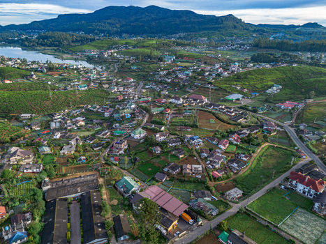 Aerial view of the town nestled among lush tea plantations and rolling hills in Nuwara Eliya Central Province Sri Lanka. Aerial view of the town nestled among lush tea plantations and rolling hills in Nuwara Eliya Central Province Sri Lanka.