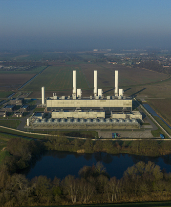 Aerial view of the Nitrogen plant with three tall white chimneys surrounded by flat agricultural fields and a small pond Zuidbroek Groningen Netherlands. Aerial view of the Nitrogen plant with three tall white chimneys surrounded by flat agricultural fields and a small pond Zuidbroek Groningen Netherlands.