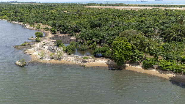 Aerial view of lush tropical vegetation along the coastline with a sandy beach and a small boat near the shore Badagry Lagos Nigeria.